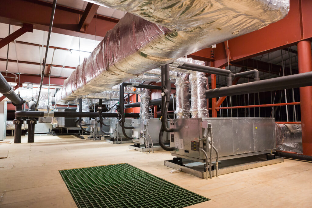 Industrial facility interior with large mechanical systems, piping, and equipment used in energy or processing operations