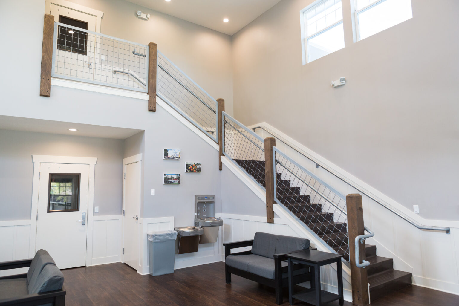 Interior common area with staircase, seating, and high ceilings at Young Life camp facility