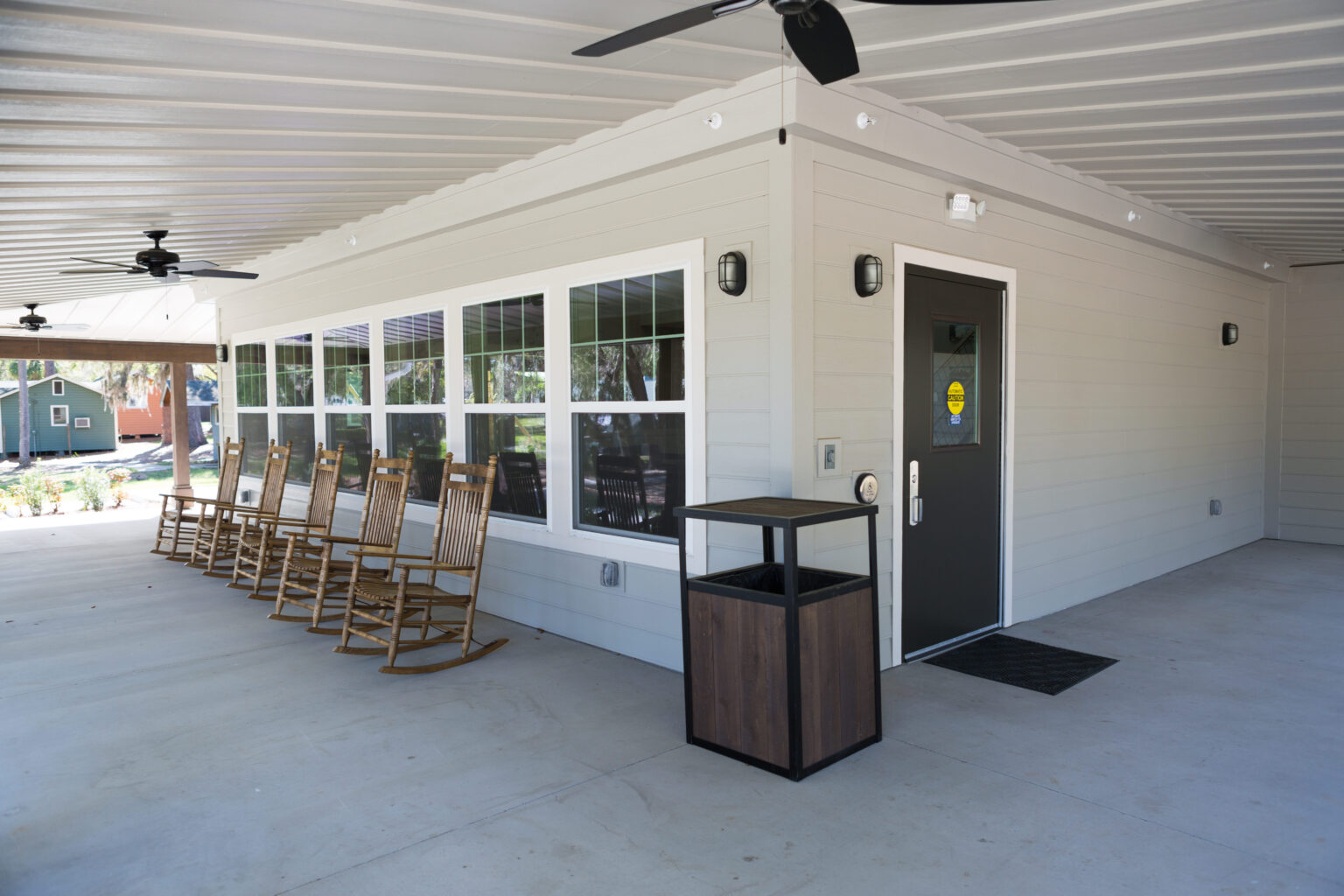Covered outdoor walkway at Young Life camp facility with rocking chairs and wood columns in North Central Florida