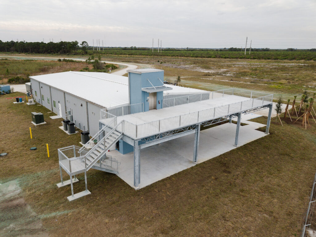 Aerial view of solar operations building next to large-scale solar panel field
