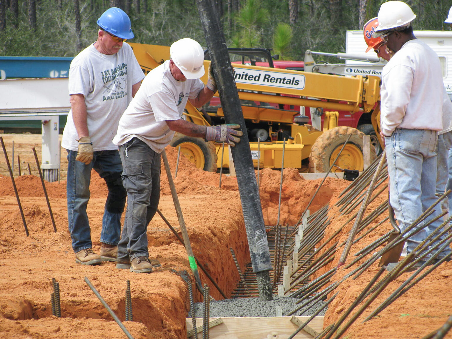 Construction crew installing underground utilities at industrial job site